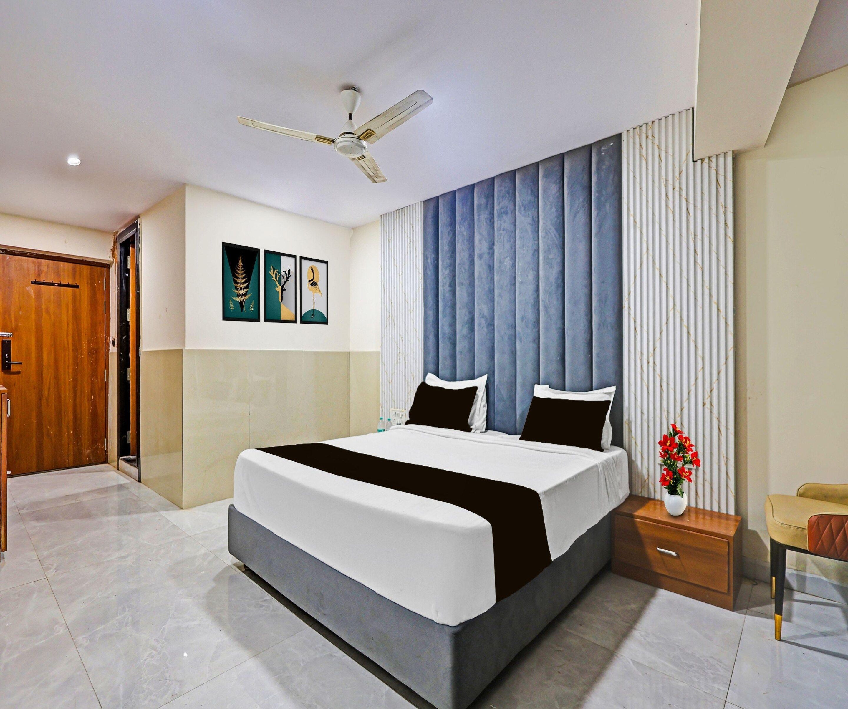A hotel room with a bed, bedside table, nightstand, and a ceiling fan.