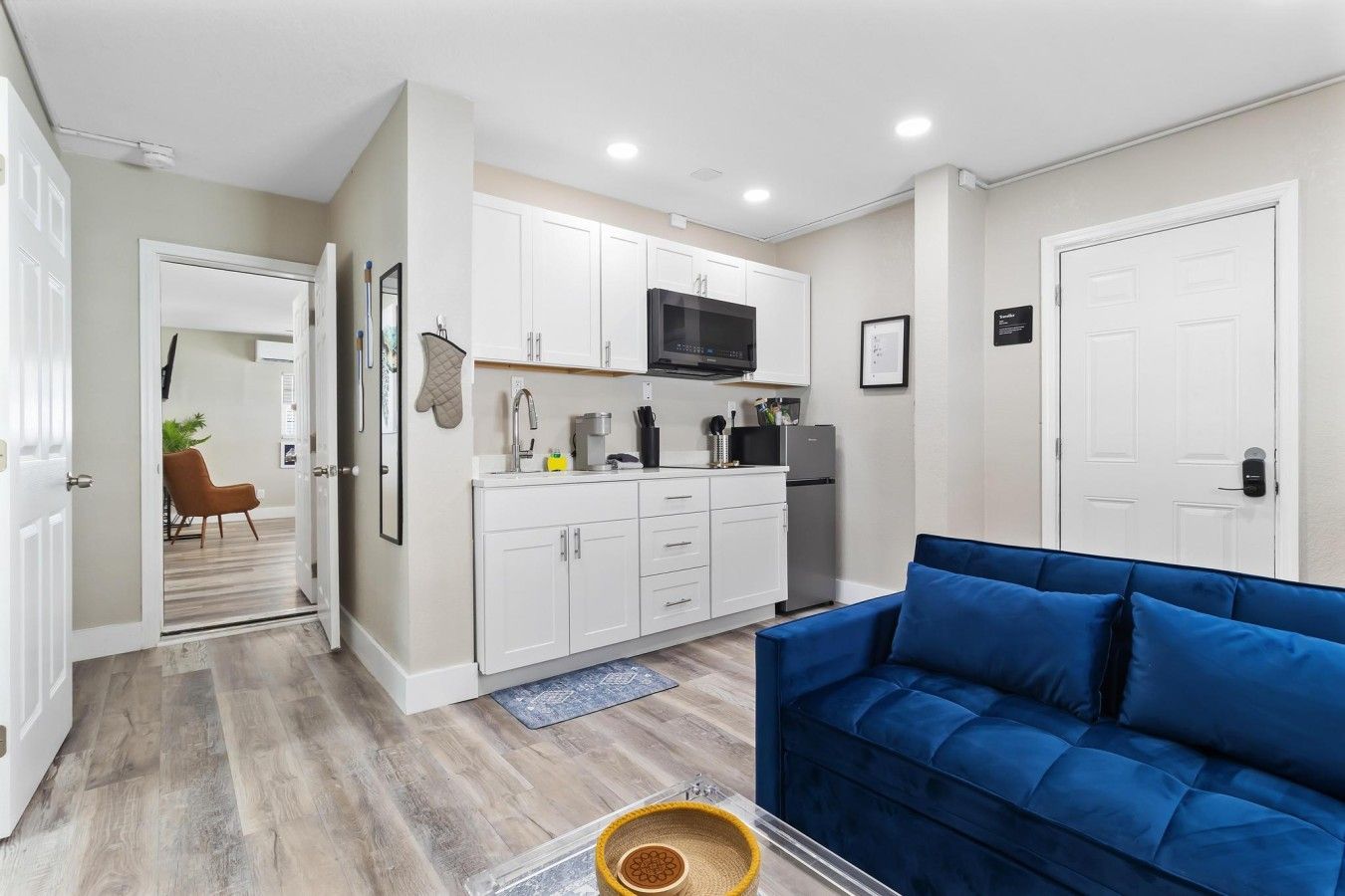 A compact living space with a kitchenette, a blue sofa, and a dining area.