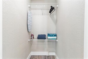 A laundry area with a hanging rack, an iron, and folded towels. - Sala Suite in St Pete Beach (St. Pete Beach)