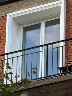 A window with a white frame and a black metal balcony railing. - Tremendous 1-bedroom apartment in cool Le Havre near the beach (Le Havre)