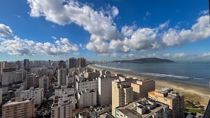 A coastal cityscape with high-rise buildings, a beach, and a clear sky. - SHB Gonzaga Lazer Completo 200m Praia (Santos)