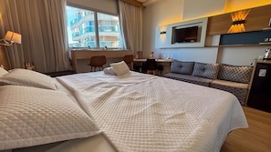 A hotel room with a large bed, a desk, a sofa, and a TV. - SHB Gonzaga Lazer Completo 200m Praia (Santos)