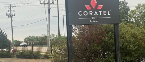 A sign for Coratel Inn by Jasper, featuring a logo and name.