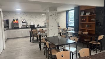 Un restaurante con paredes de mármol, muebles de madera y vista a la calle.