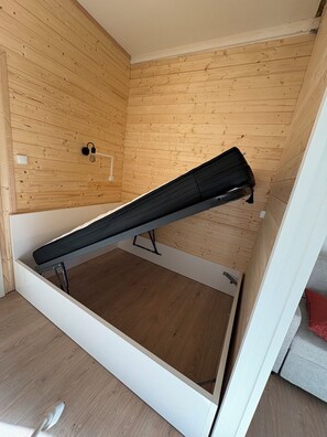Ein Zimmer mit Etagenbett, Holzwänden und einer weißen Tür.