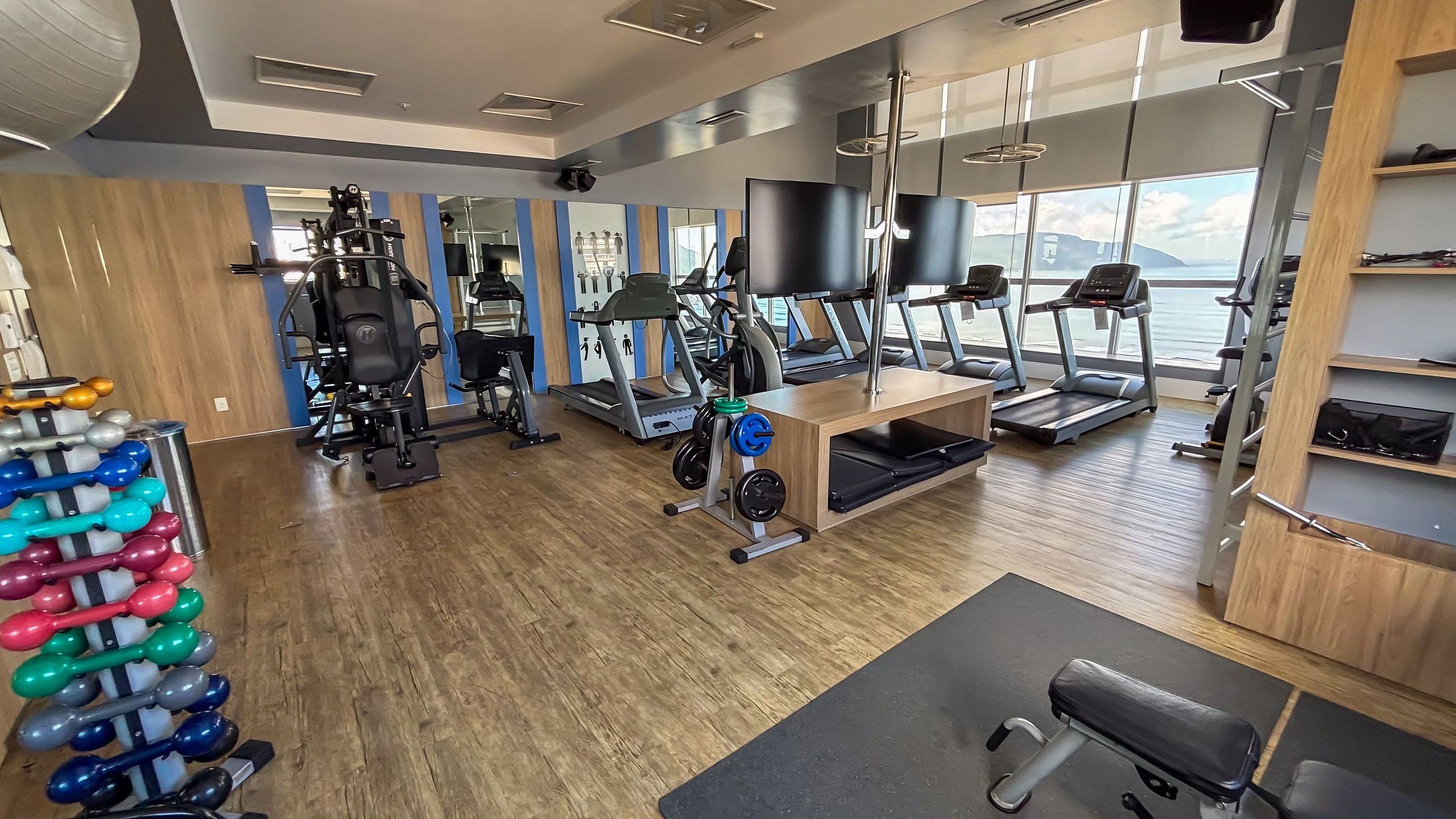 A gym with treadmills, weight machines, and free weights.