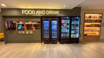 A food and drink kiosk with vending machines and a small counter area.