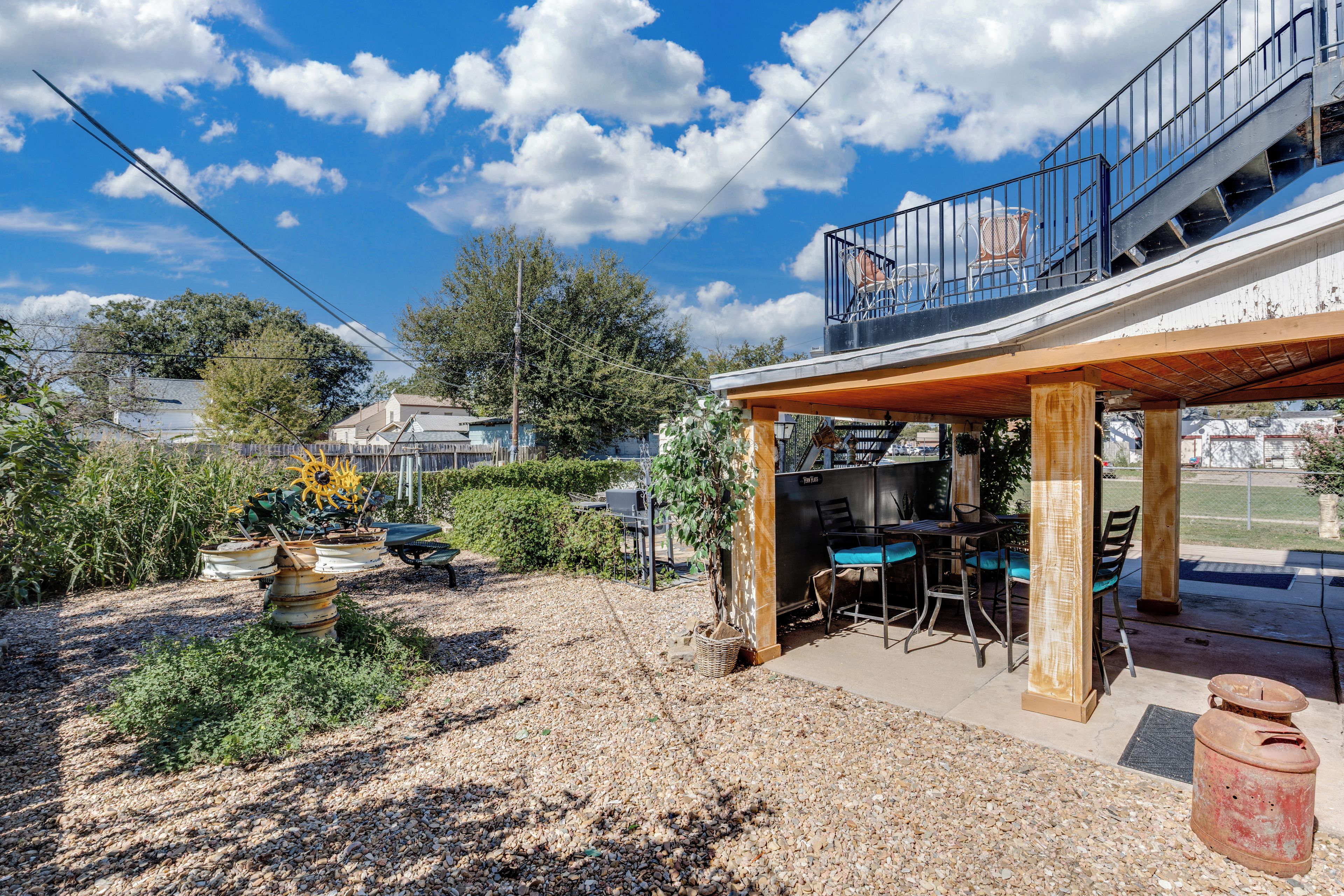 Un área de patio con mobiliario exterior, un pérgola y vistas al cielo.
