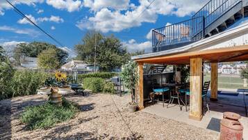 Un área de patio con mobiliario exterior, un pérgola y vistas al cielo.