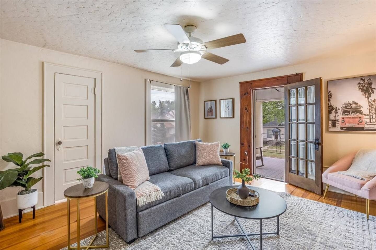 Bright, cozy living room with French doors opening to a charming porch