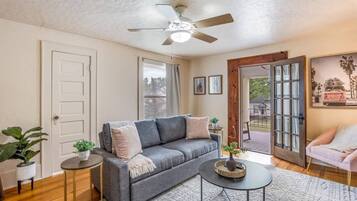 Bright, cozy living room with French doors opening to a charming porch