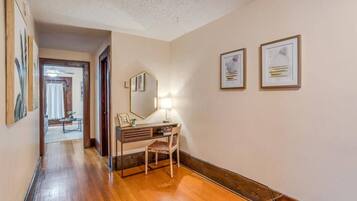 Warm hallway with hardwood floors, art, and a charming desk nook