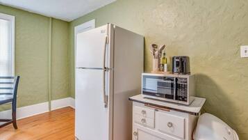 Bright kitchen nook with full-size fridge and convenient countertop appliances