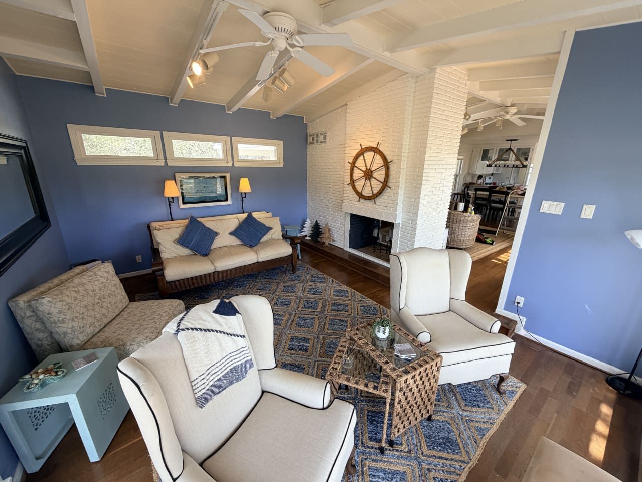 A living room with a sofa, armchairs, a coffee table, and a fireplace.