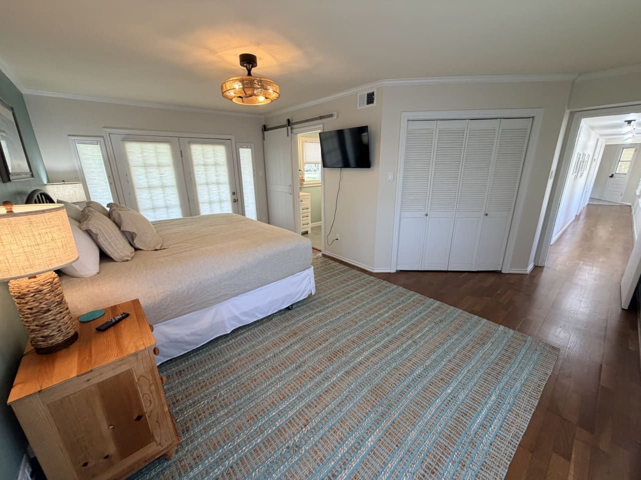 A bedroom with a bed, a television, a lamp, and a wardrobe.