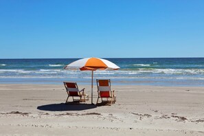 A beach with two beach chairs and a beach umbrella. - Rockport Runaway Retreat (Rockport)
