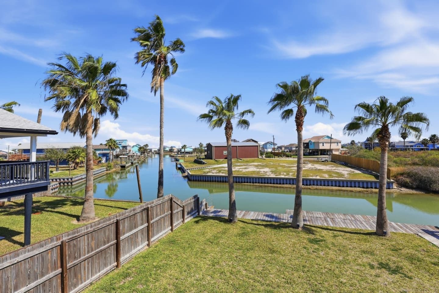 A residential area with a canal, wooden docks, and houses.