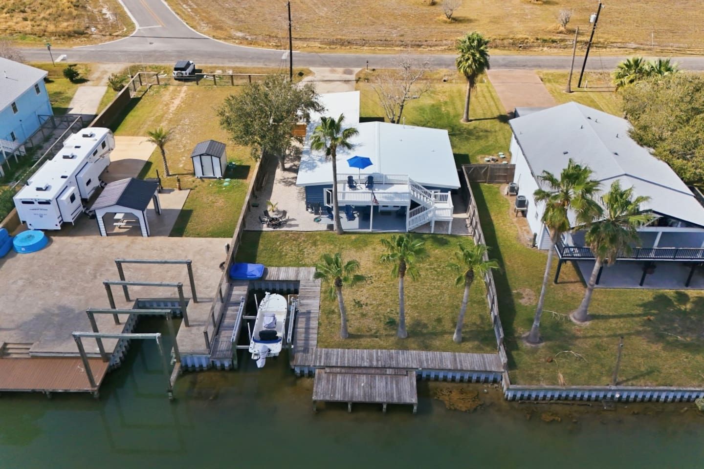 Un quartier résidentiel comprenant un quai, un emplacement pour camping-car et une maison dotée d’un patio couvert.
