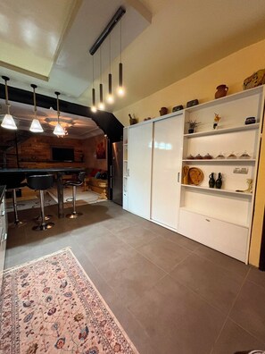 A modern kitchen with a bar area, pendant lighting, and a patterned rug. - Stunning, Cozy, and Modern Duplex – 5 min from the Airport & 15 min from Downtown (Marrakech)