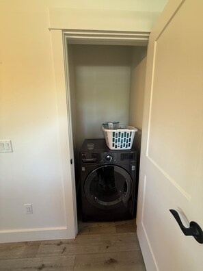 A laundry room with a washing machine and a basket. - New build 2-bedroom 2 Bath condo with AC in welcoming Bozeman (Bozeman)