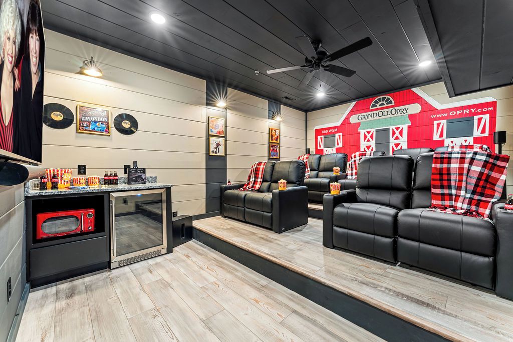 A modern living room with a fireplace, leather sofas, and a red and white decor theme.