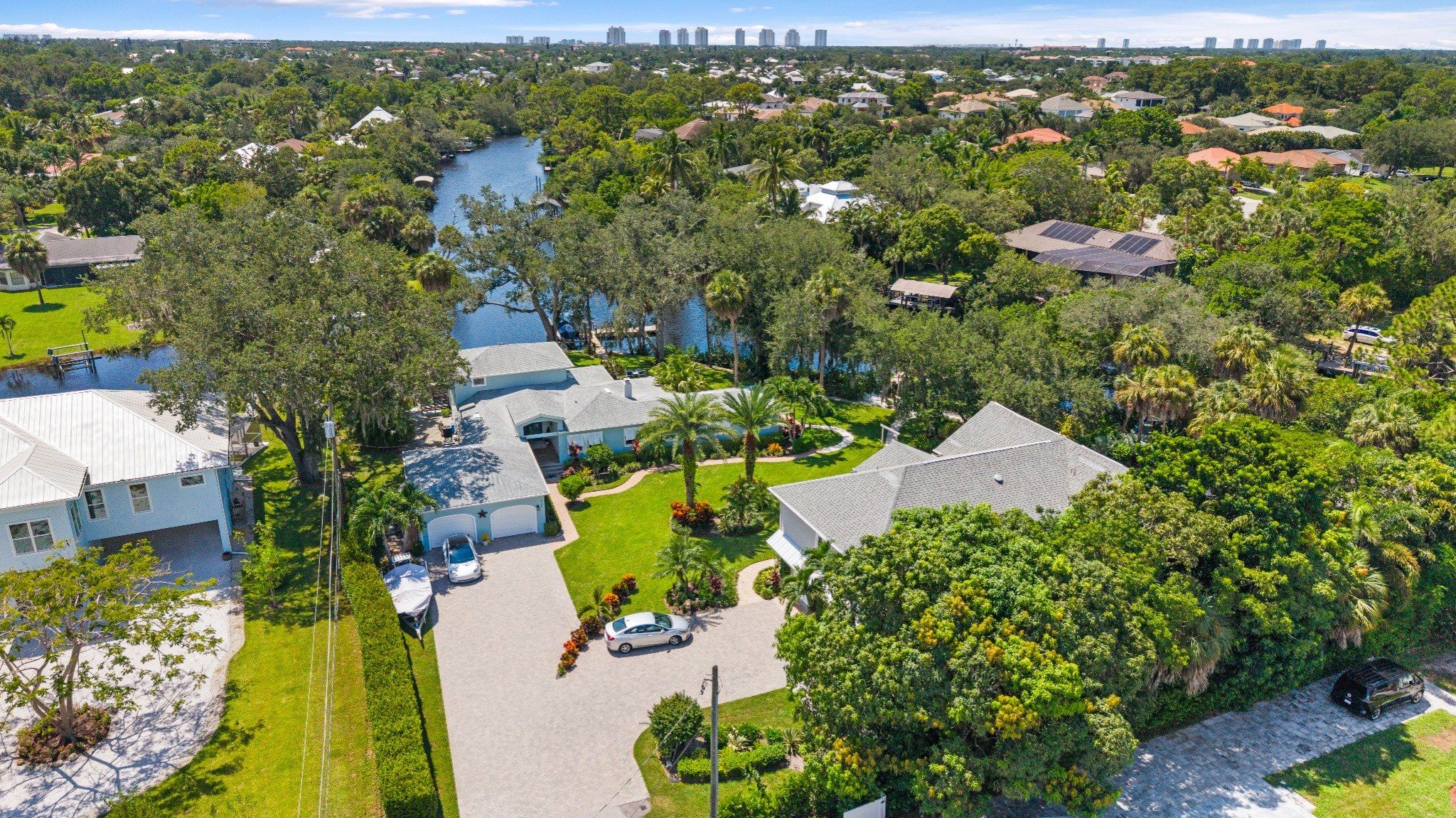 A residential area with houses, a river, and a clear sky.