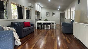 A modern living space with a dining area, kitchen, and seating arrangements.