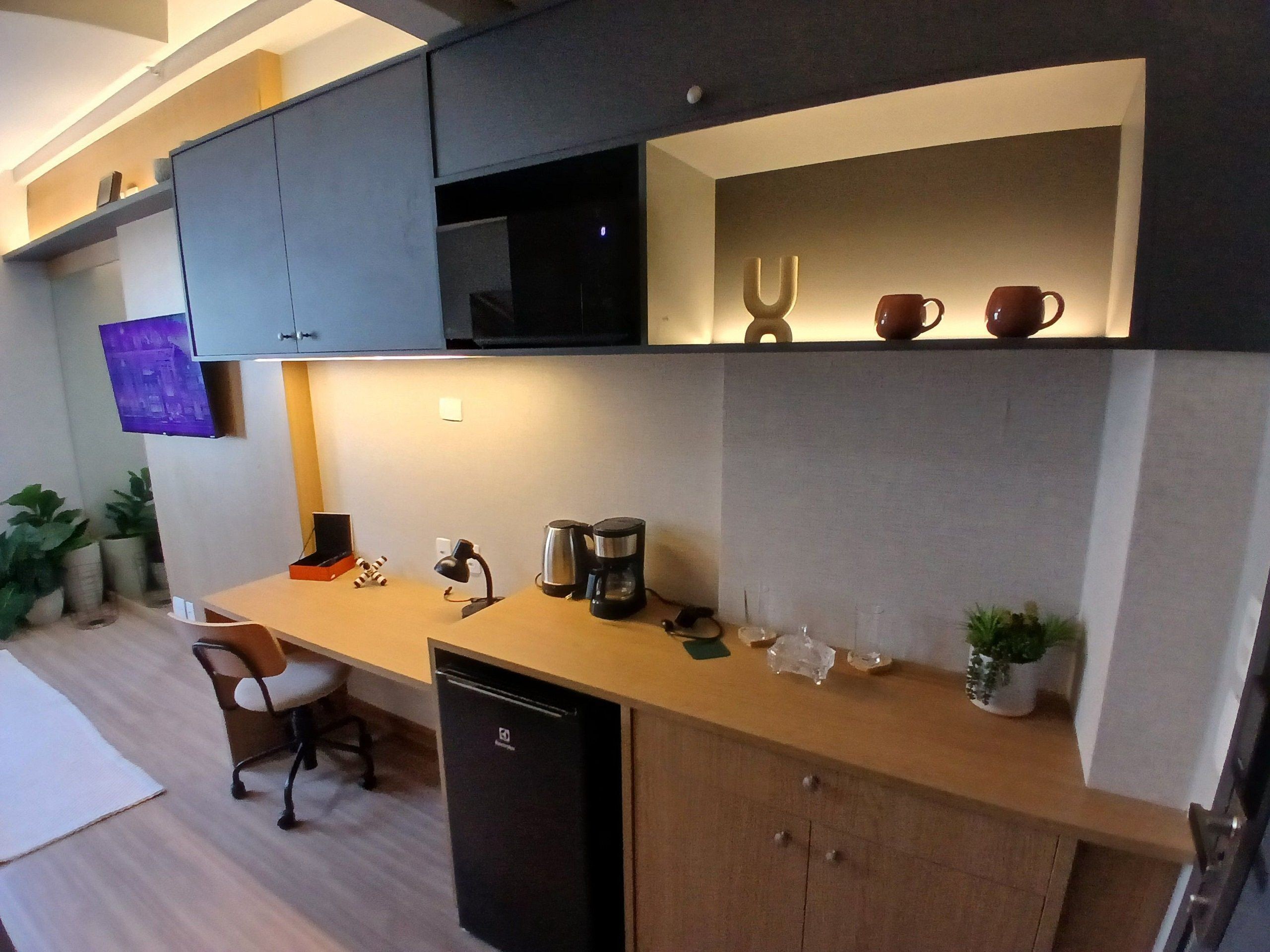 A compact kitchen with a microwave, coffee maker, and a small refrigerator.