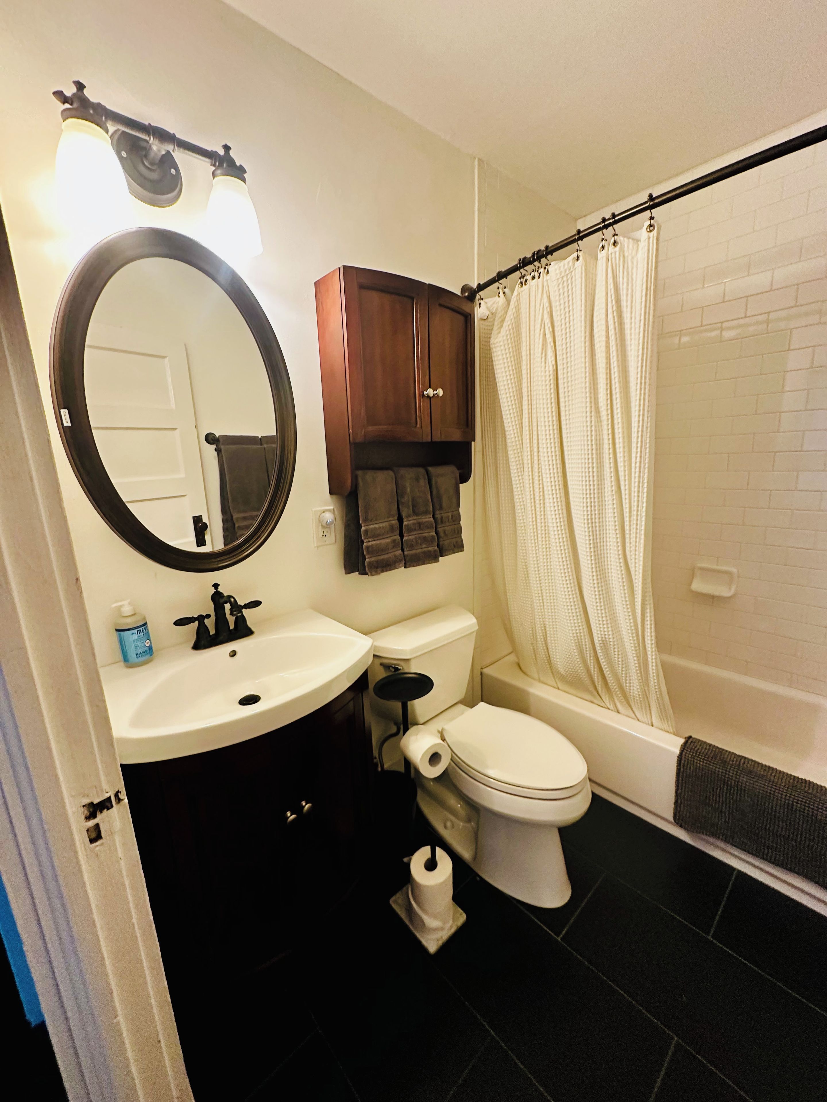 A bathroom with a toilet, sink, and bathtub.