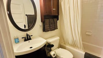 A bathroom with a toilet, sink, and bathtub.