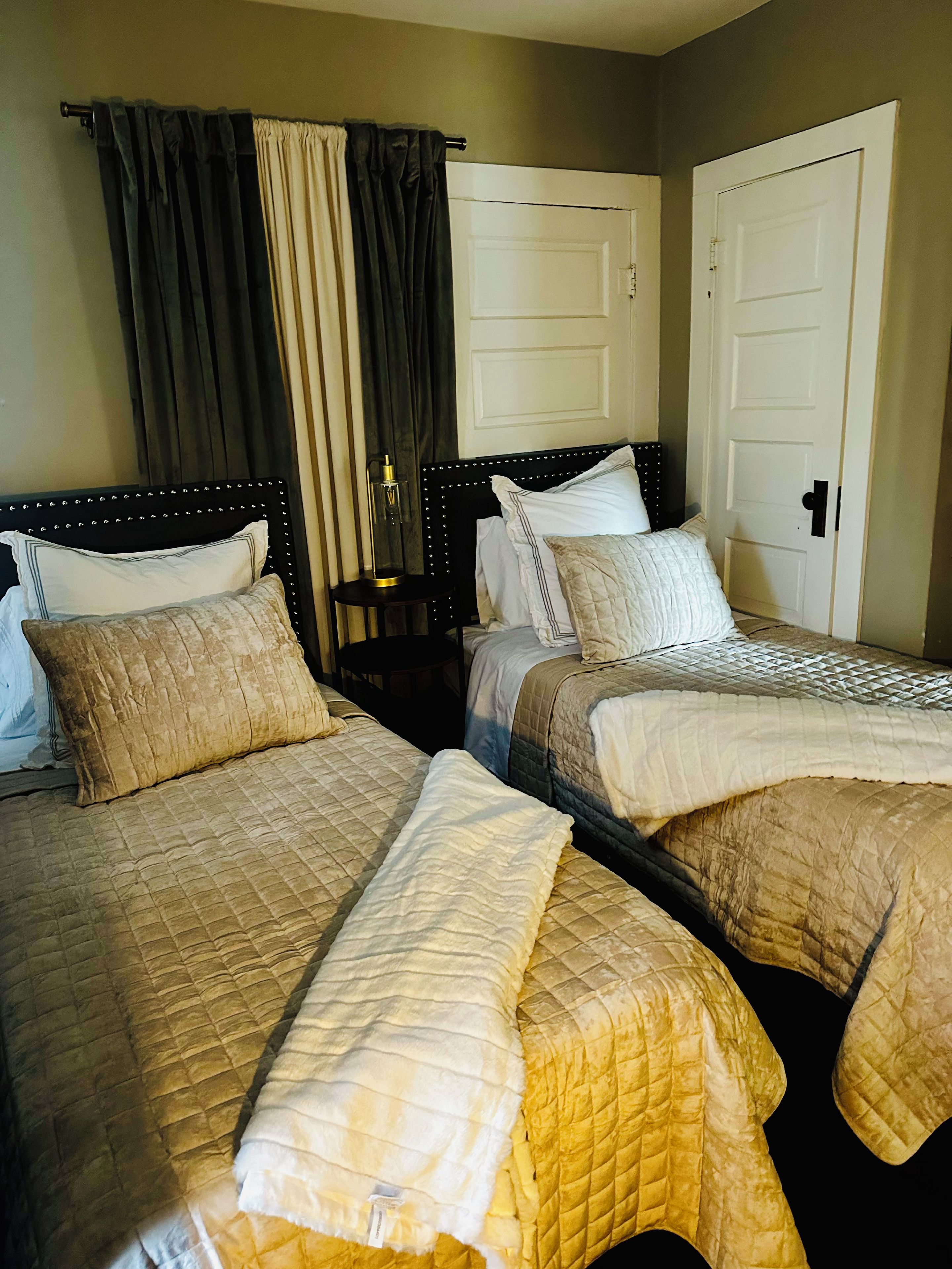Une chambre d’hôtel avec deux lits, une table de chevet et une lampe.