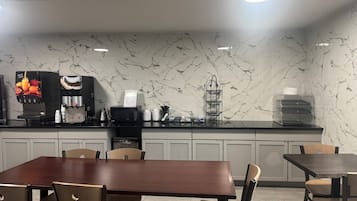 A modern kitchen with a marble backsplash, a coffee machine, and a water dispenser.