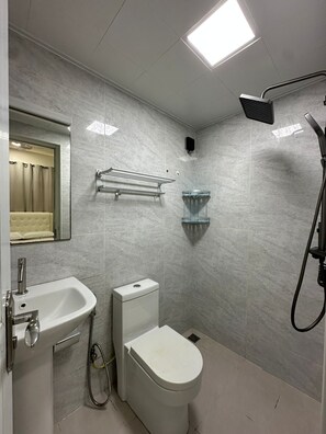 Un baño con inodoro, lavabo y ducha.