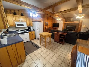 A compact kitchen with wooden cabinets, a microwave, stove, and a refrigerator.
