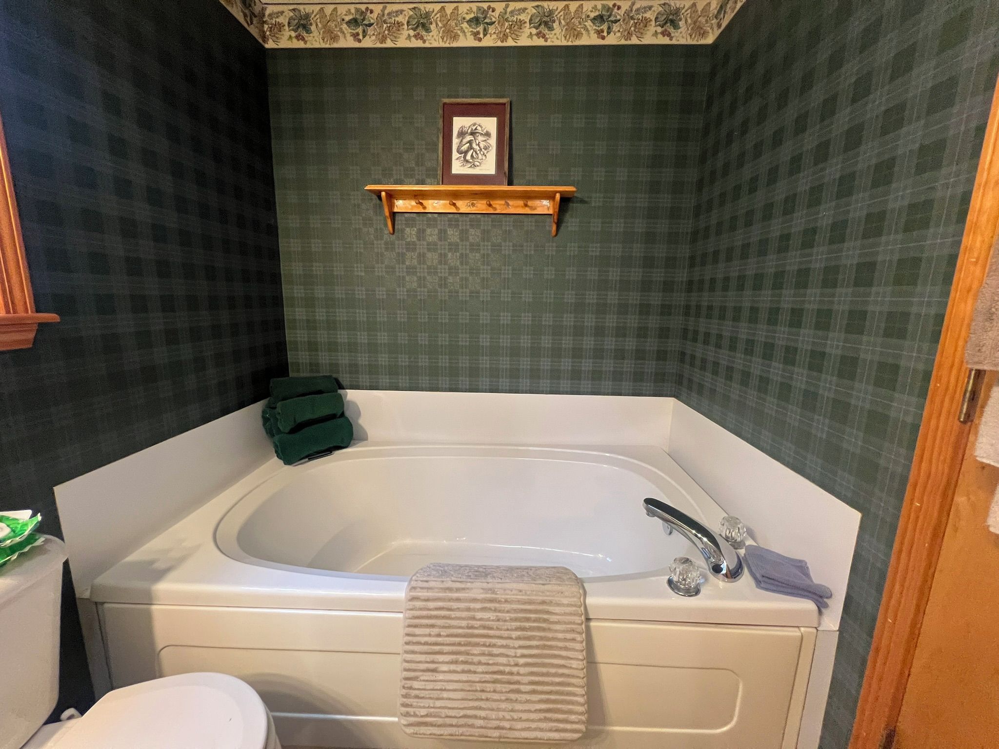 A bathroom with a bathtub, a toilet, and a shower area.