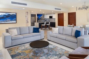 A modern living room with two grey sofas, a coffee table, and a patterned rug.