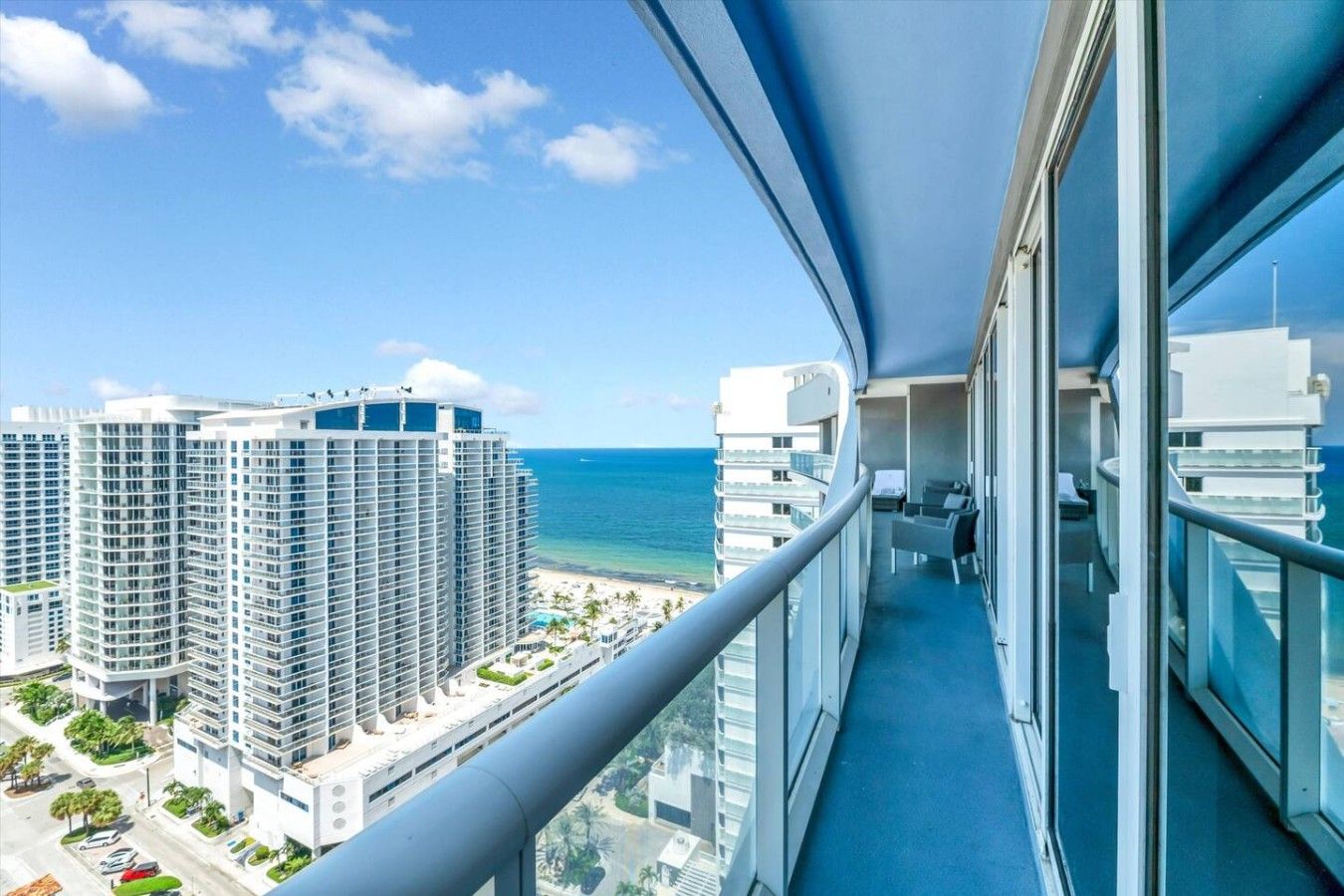 Ein Balkon mit Blick auf einen Strand und hohe Gebäude.