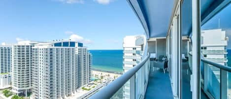 A balcony with a view of a beach and high-rise buildings.