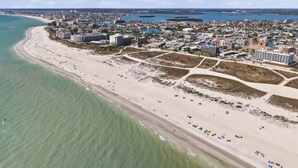 An aerial view of a coastal city with a wide beach, clear blue waters, and a dense urban area with buildings. - Spacious 5-bedroom townhome in charming Treasure Island with Rooftop Hot tub (Treasure Island)