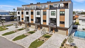 A modern multi-story residential building with balconies, a swimming pool, and a well-maintained garden. - Spacious 5-bedroom townhome in charming Treasure Island with Rooftop Hot tub (Treasure Island)