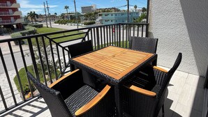 A balcony with a table and chairs, a view of the street, and buildings in the background. - Spacious 5-bedroom townhome in charming Treasure Island with Rooftop Hot tub (Treasure Island)