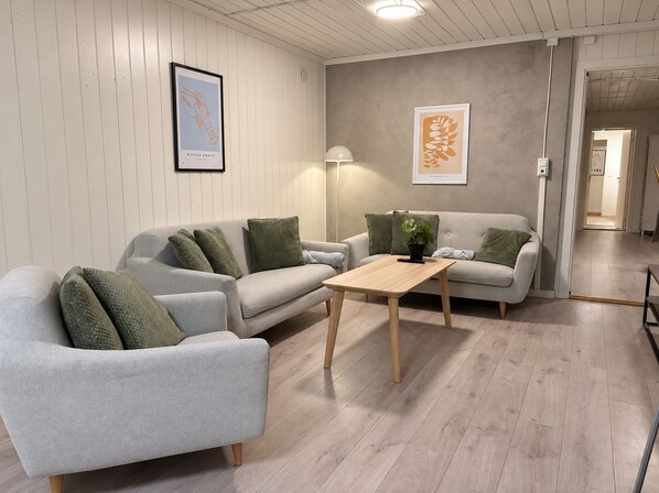 Un salon moderne avec un canapé gris, une table basse en bois et une plante verte.