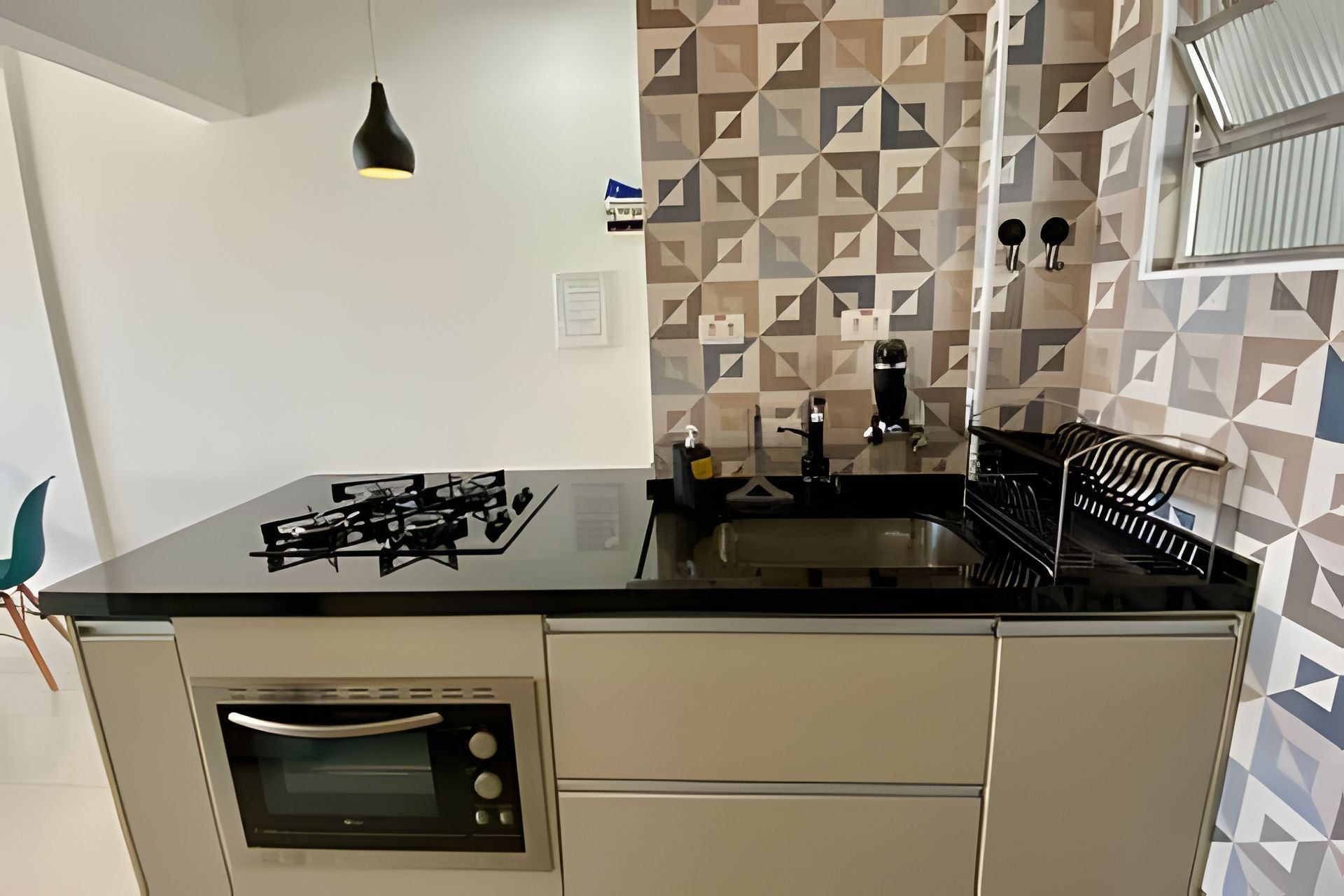 Una cocina con estufa a gas, horno y un lavamanos moderno.