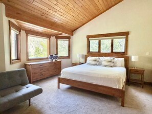 A bedroom with a wooden ceiling, a bed, a dresser, a chair, and two bedside tables. - Beautiful 4BR on Vail Golf Course/Step to Bus Stop/Hot Tub (Vail)