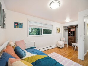 A bedroom with a bed, a chair, a desk, and a wardrobe. - South Hill Mid Century Bliss (Spokane)