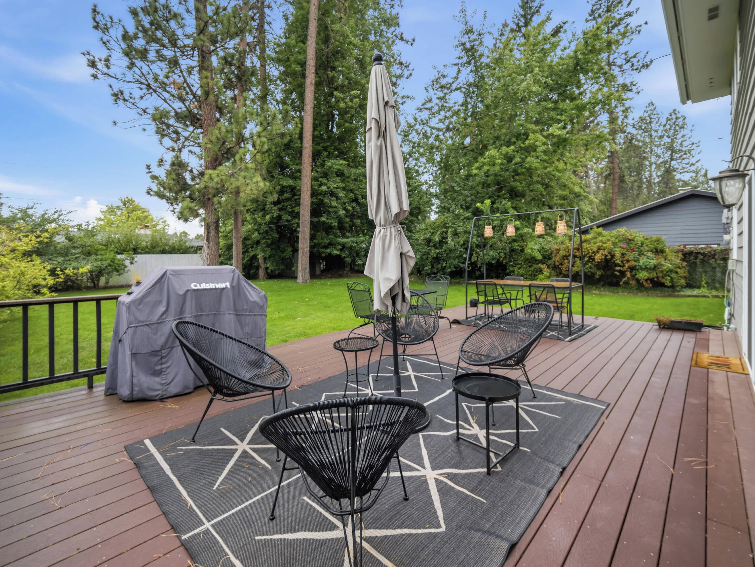 A deck with outdoor furniture, a grill, and a covered area.