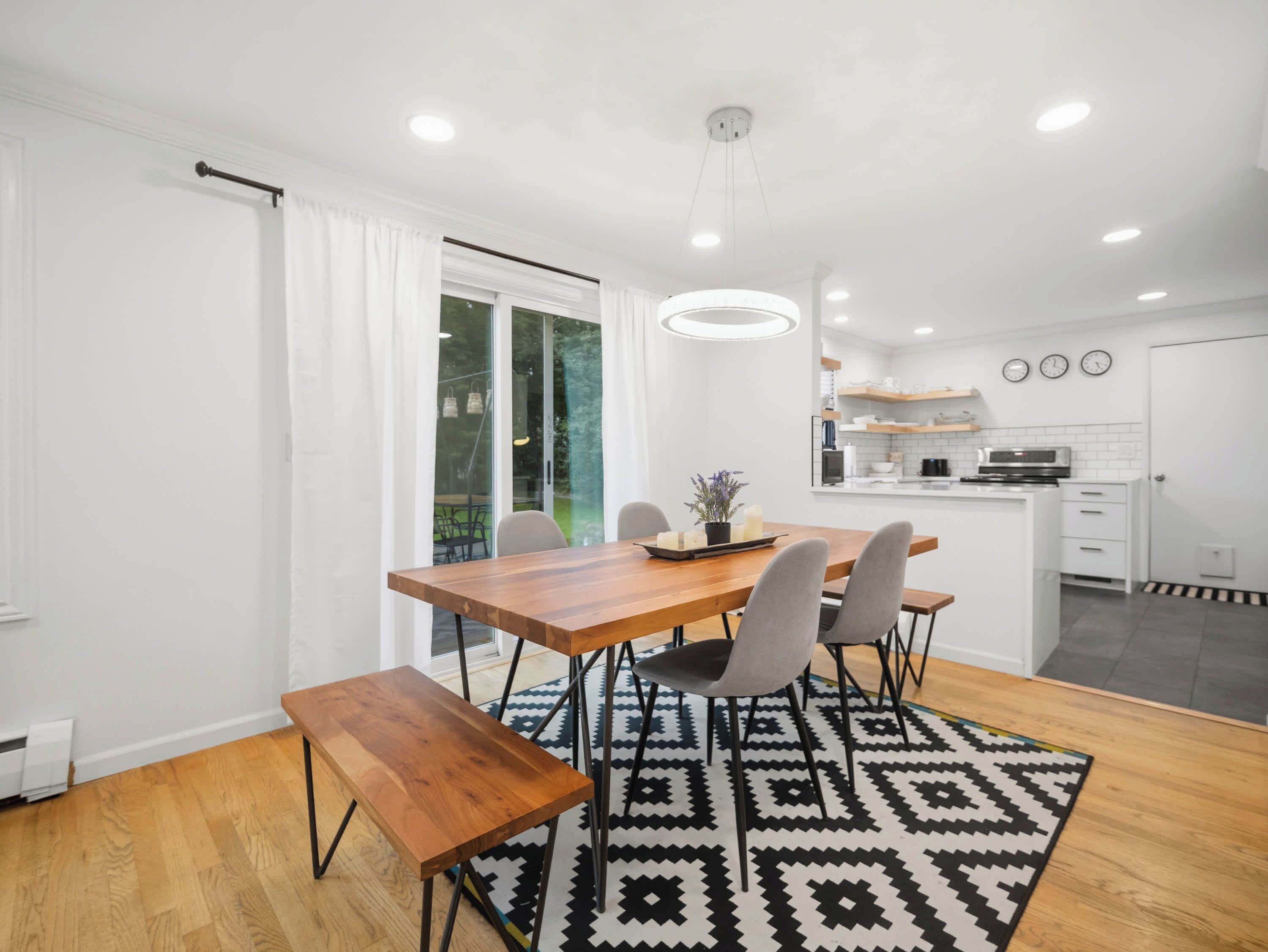 A modern kitchen with white cabinets, a built-in oven, and a microwave.