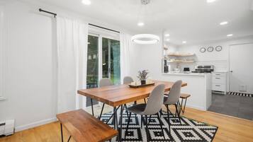 A modern kitchen with white cabinets, a built-in oven, and a microwave.