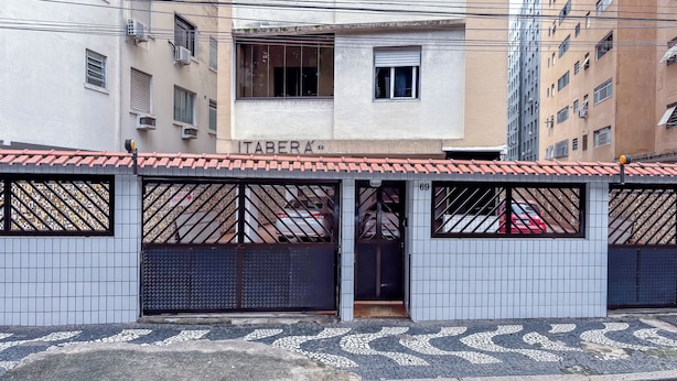 A building with a tiled roof, a visible storefront, and a gated entrance with a tiled floor. - SHB - Orquidário 3 min Praia em Studio (Santos)