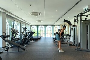 Ein Fitnessstudio mit Laufbändern, Kraftgeräten und einer trainierenden Person.